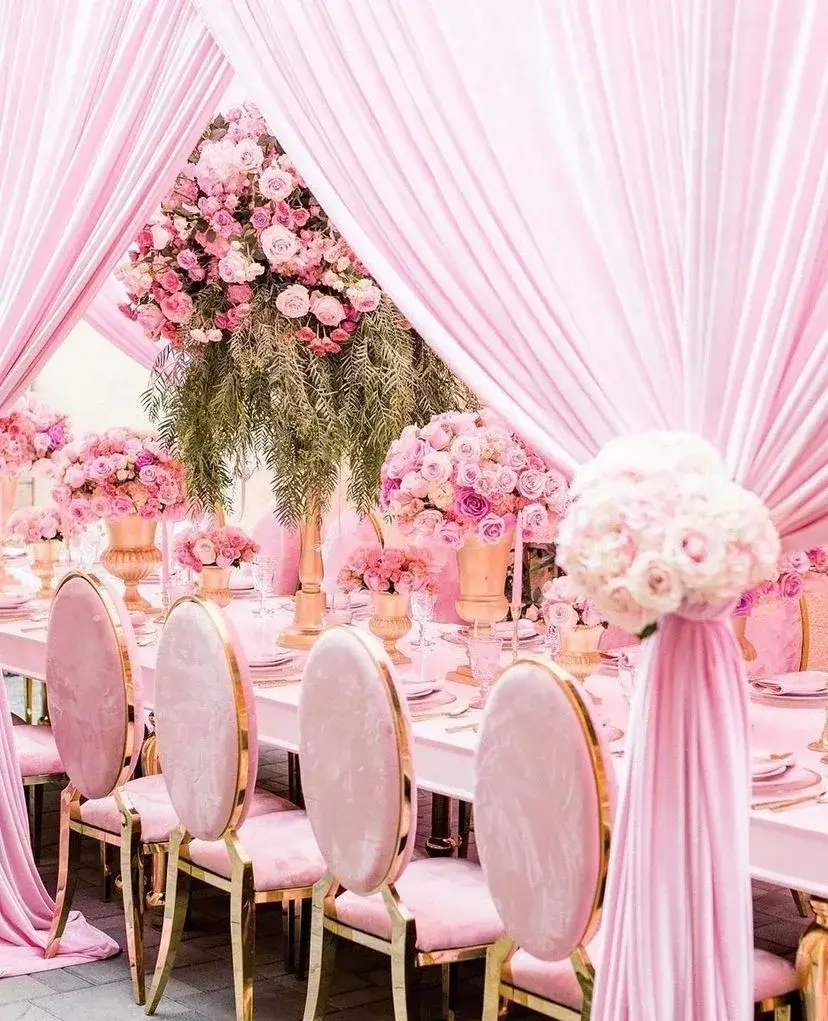 A pink and gold wedding reception set up.