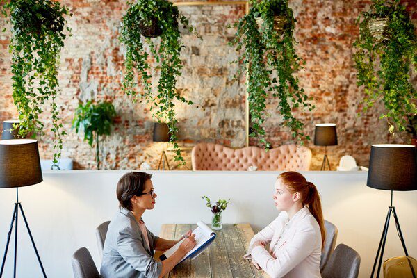 Two women talking at a table in an office.