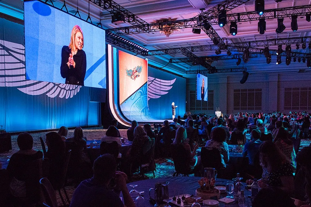 A group of people sitting at tables at an event.